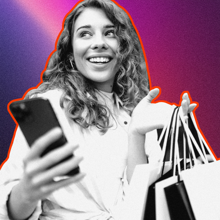 Woman holding mobile device and a few shopping bags with a smile