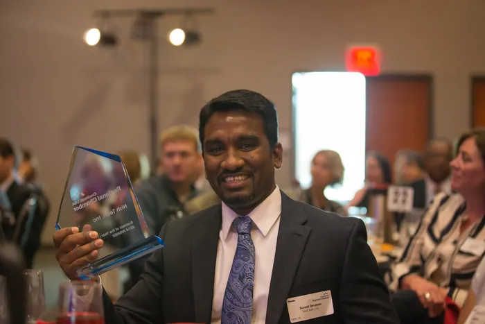 Suresh Devanan holding the Small Business Award, 2014.