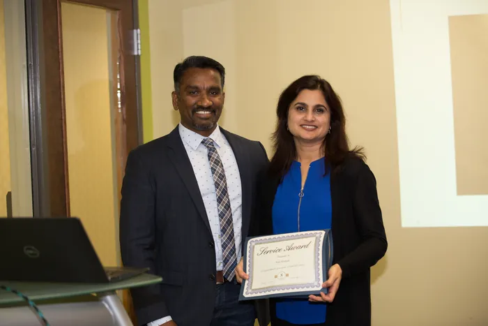 Suresh Devanan presenting a service award to a member of the Nishtech team, 2019.